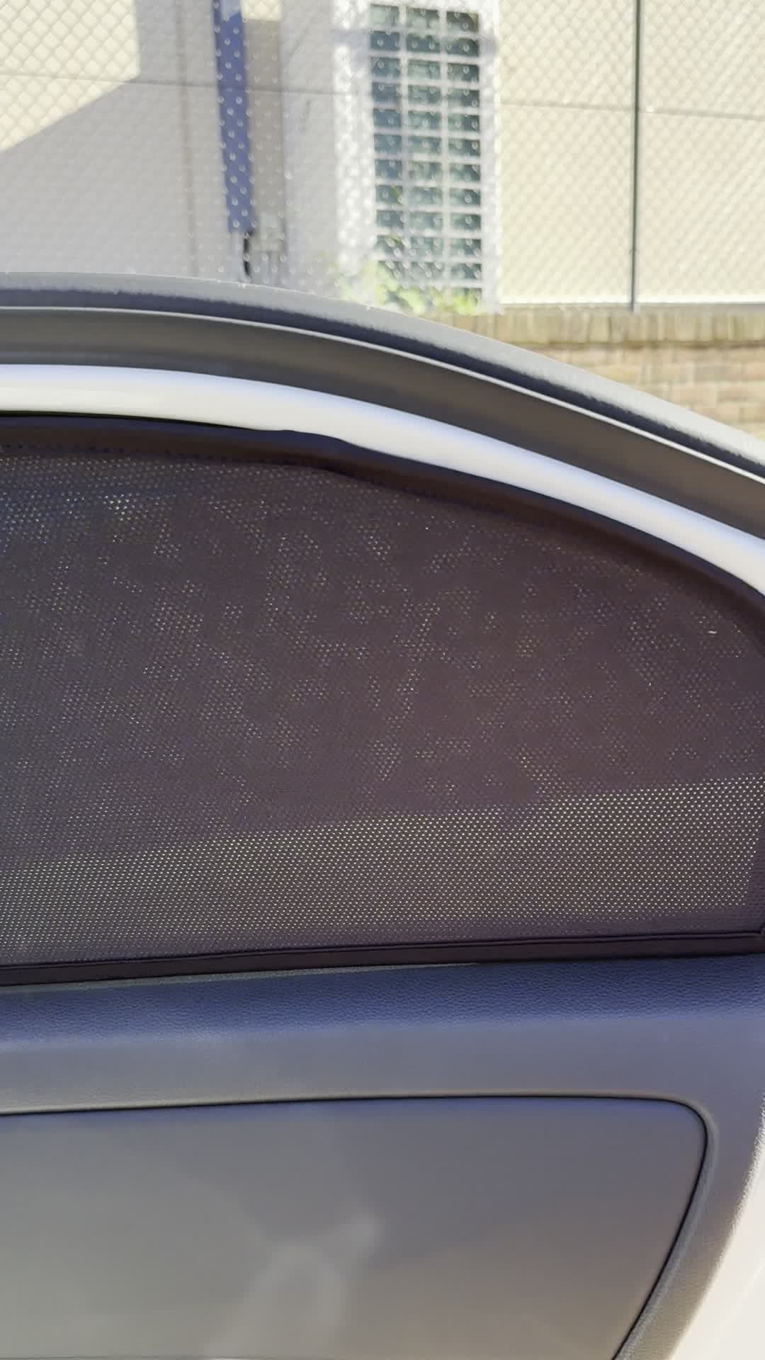 A custom-fit magnetic mesh sun shade fitted to a car window