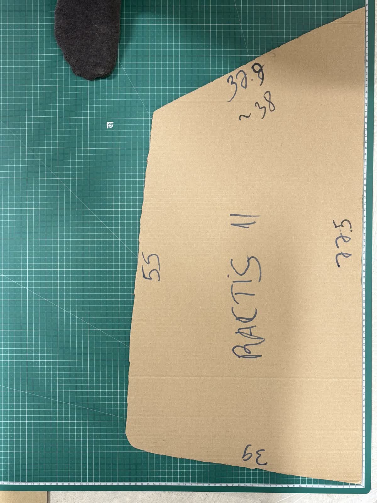 A hand-cut cardboard template for a specific vehicle's window